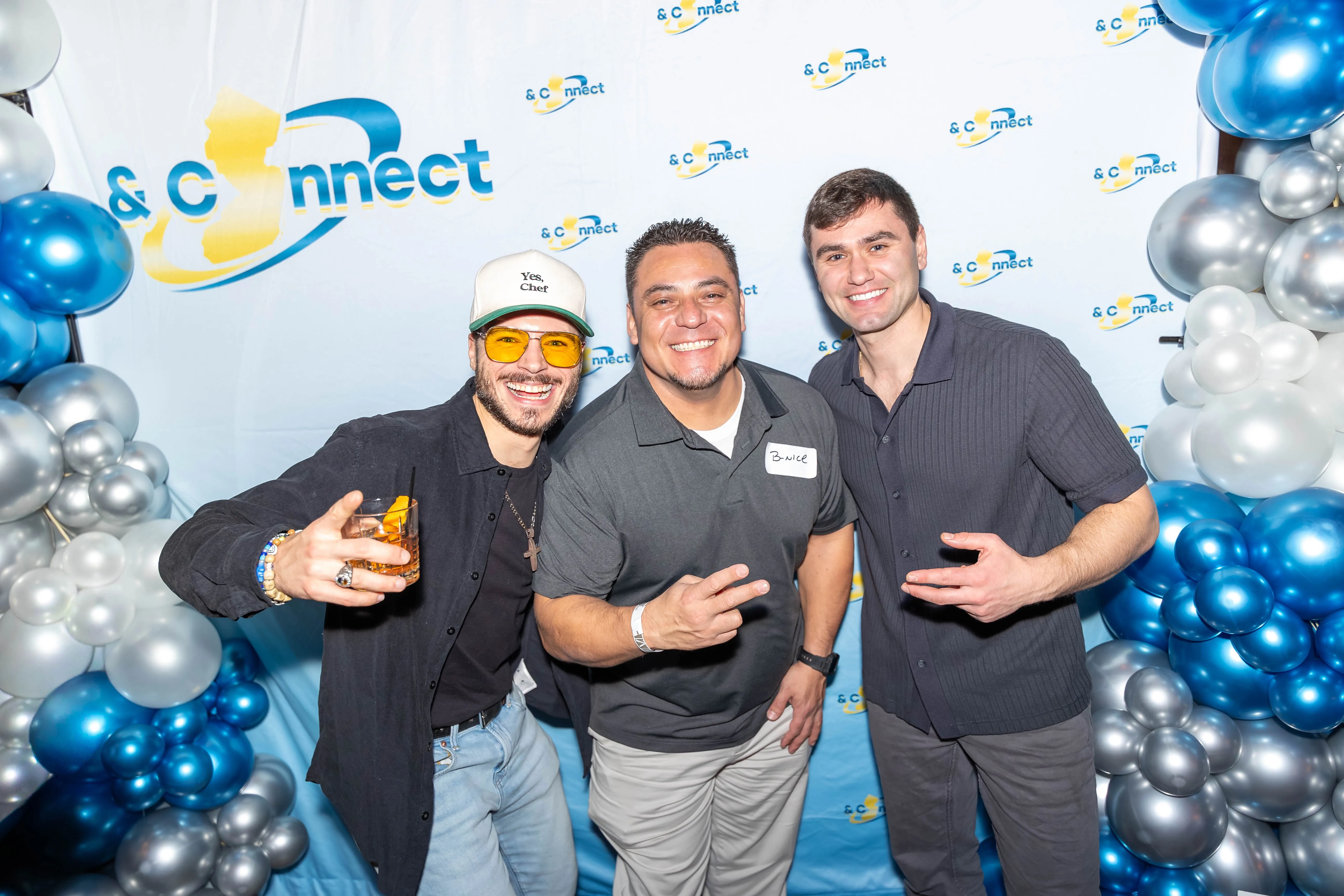 Three attendees posing together at a Battle Connects backdrop